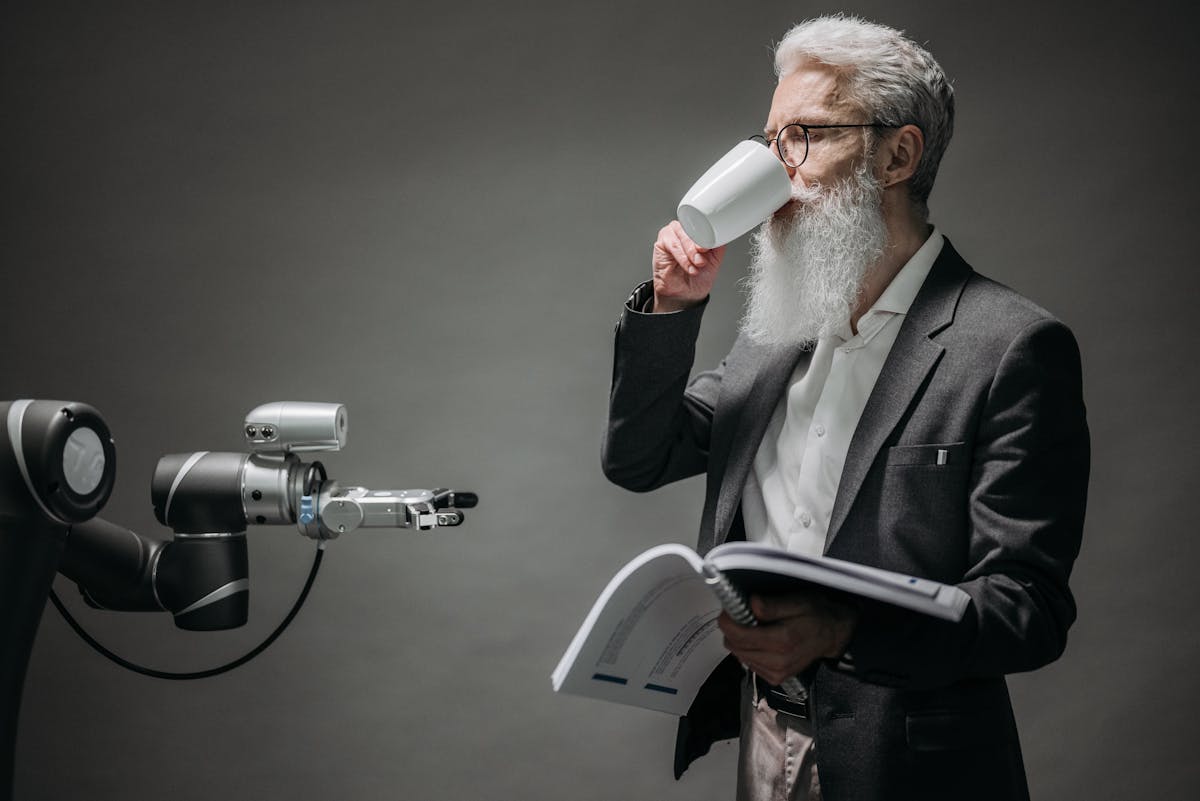 Developer with technical manual beside a robotic arm, illustrating AI Agent Memory beyond chat logs