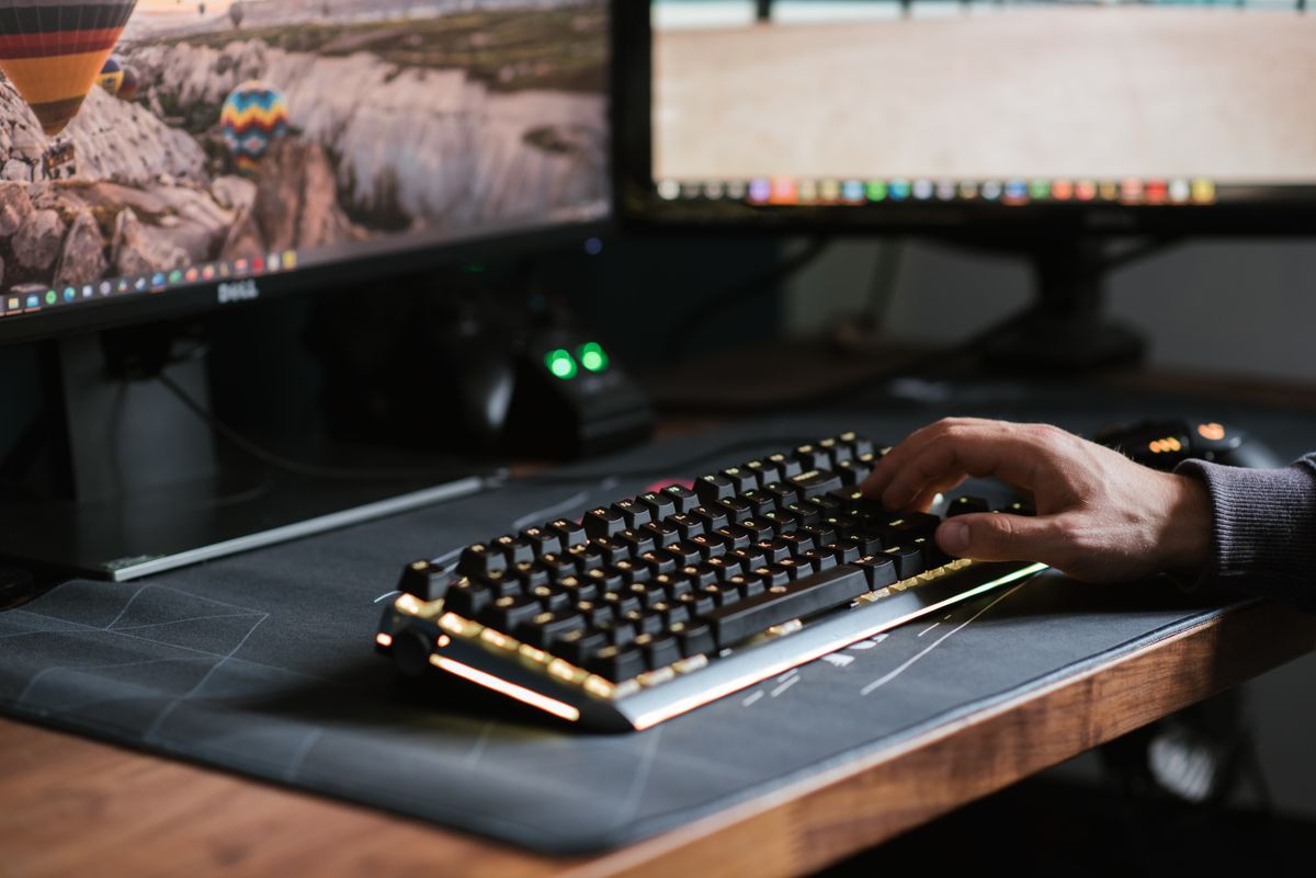 Hand auf beleuchteter Tastatur am Entwickler-Arbeitsplatz — Claude Code Rules, Skills und Workflow Konfiguration