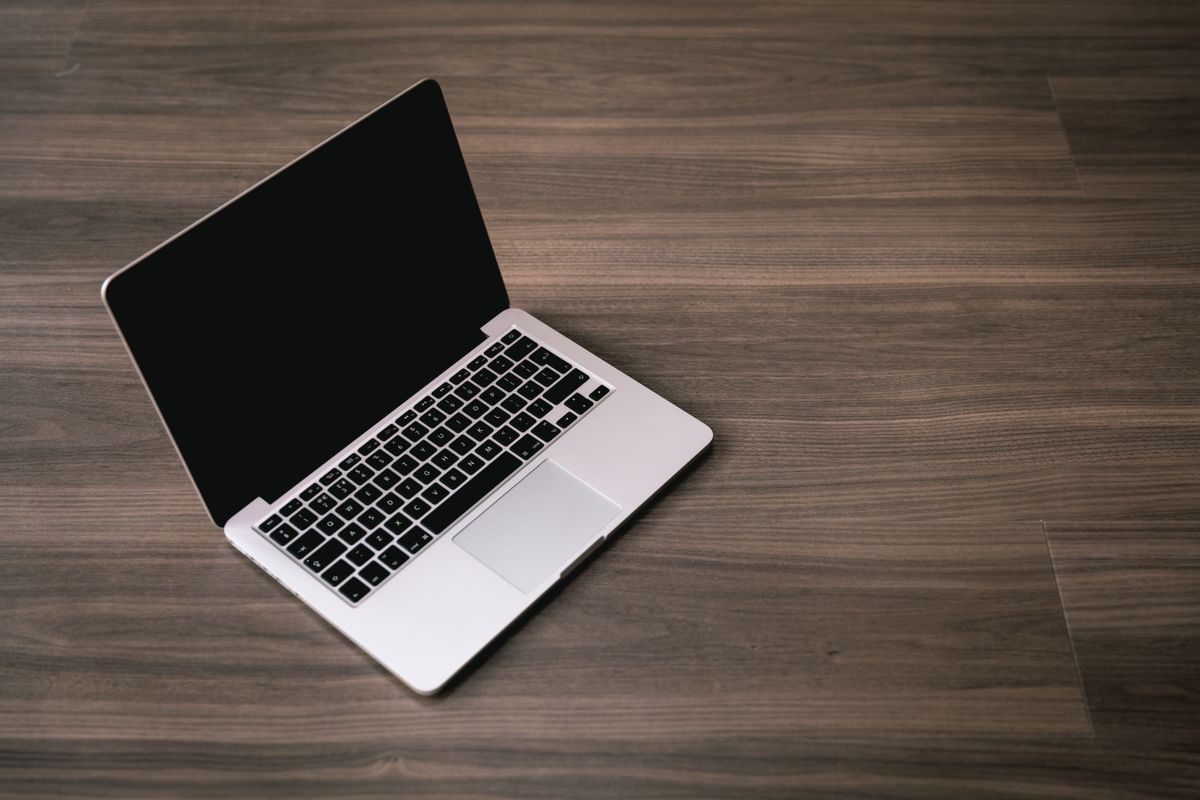 Open silver laptop on a dark wood floor